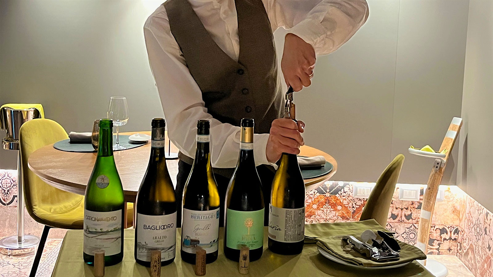 A restaurant server opening bottles of wine from members of the Salt West assocation